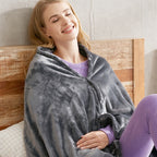 Femme souriante enveloppée dans le plaid chauffant USB gris