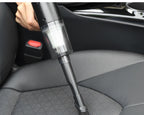 Aspirateur à main utilisé sur un siège de voiture